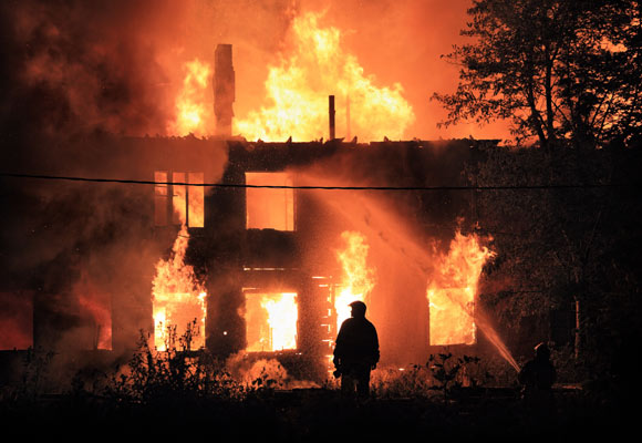fireman watching structure burning